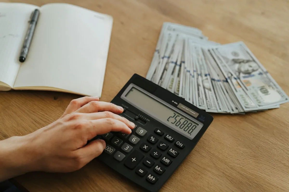 Persona calculando su margen mensual con una libreta