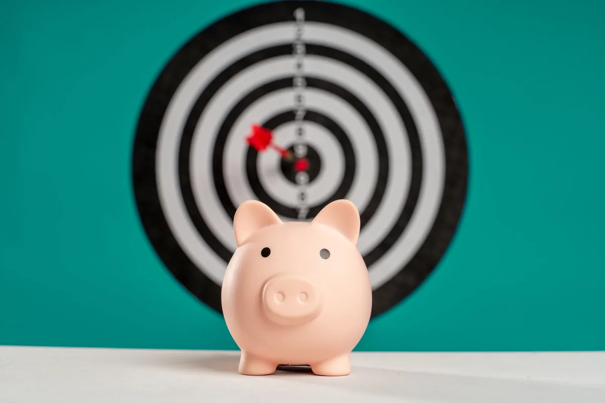 Persona anotando un objetivo financiero y un plazo